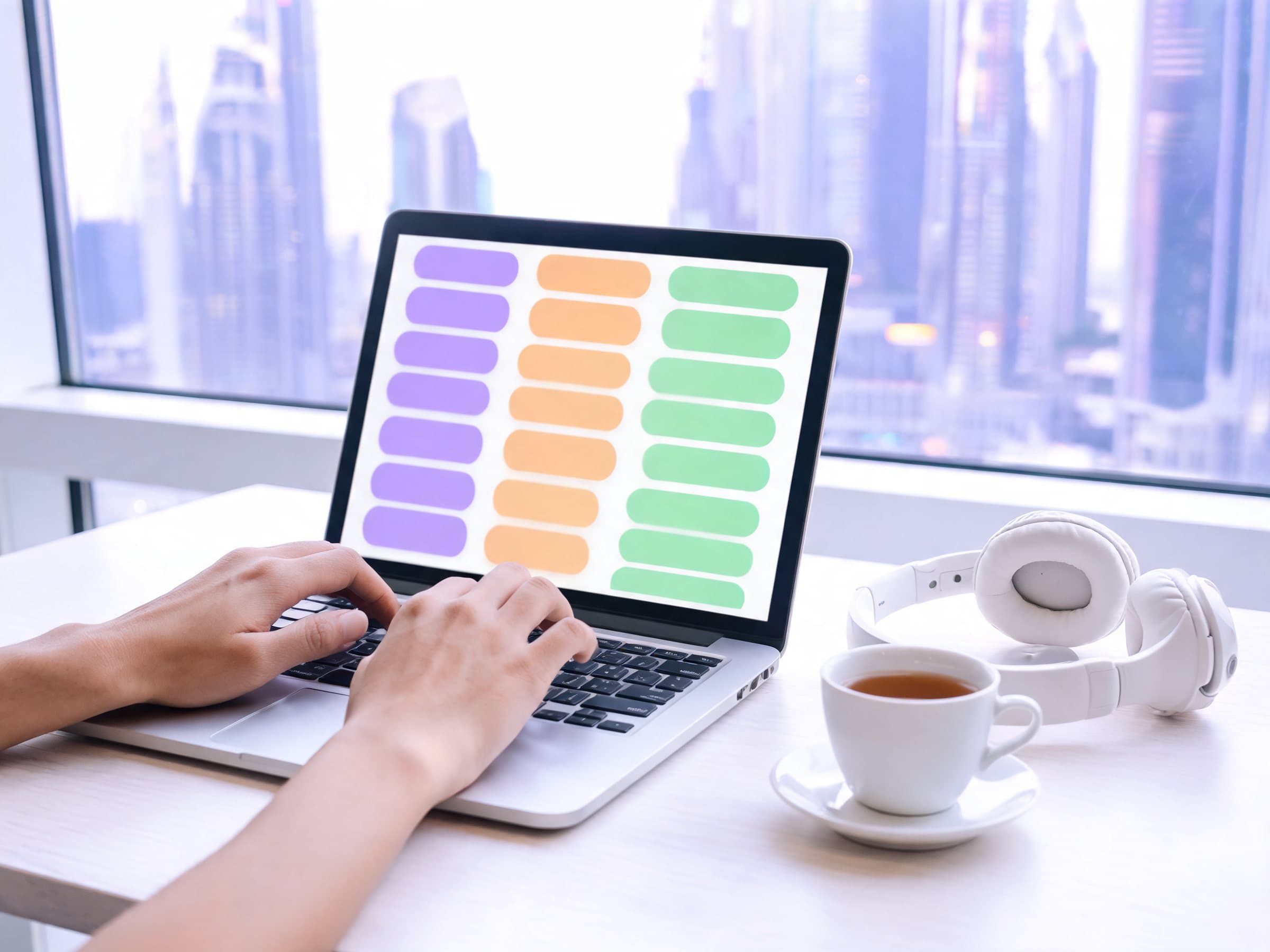Hands typing on a laptop showing ticket cards in three columns, beside a headset and a cup of tea, in a Dubai office